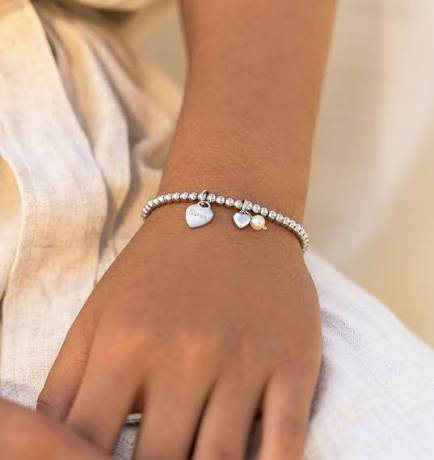 Zilveren balletjesarmband met hartje en parel om een pols